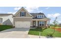 Charming craftsman-style home with a manicured lawn and two-car garage on a sunny day at 49 Masters Dr, Villa Rica, GA 30180