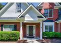 Inviting front porch featuring brick columns, manicured bushes, and a black front door at 1245 Grace Hadaway Ln, Lawrenceville, GA 30043
