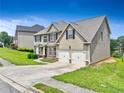 Two-story home with tan siding, brick accents, and attached two-car garage with well-manicured lawn at 766 Chapman St, Jonesboro, GA 30238