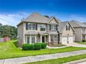 Two-story home with tan siding, brick accents, two-car garage and well-manicured lawn near the water at 766 Chapman St, Jonesboro, GA 30238