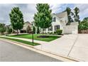 View of a two-story home with manicured lawn, long driveway and attached garage at 148 Sierra Cir, Woodstock, GA 30188