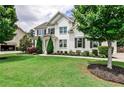 Charming two-story home with a pristine lawn and beautiful, mature trees at 148 Sierra Cir, Woodstock, GA 30188
