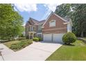 Brick home showcasing a long driveway, manicured lawn, and an attached two-car garage at 250 Lawrence Pl, Atlanta, GA 30349