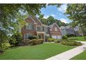 Lovely two-story brick home with a well-kept lawn and mature trees at 250 Lawrence Pl, Atlanta, GA 30349