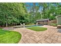 Inviting backyard oasis with a luxurious pool, pergola, and beautiful stone patio area at 3987 Tamarack Nw Dr, Kennesaw, GA 30152