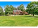 Expansive front yard view of the home, displaying its brick facade and mature landscaping at 3987 Tamarack Nw Dr, Kennesaw, GA 30152