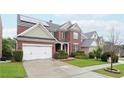Beautiful two-story brick home in a residential neighborhood with a manicured lawn and solar panels at 1489 Belmont Hills Dr, Suwanee, GA 30024