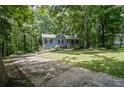 Quaint home with a front yard surrounded by mature trees providing shade and privacy at 3030 Winchester Dr, Cumming, GA 30041