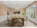 Elegant dining room featuring wood floors, decorative trim, and large window at 5156 Amberden Hall Dr, Suwanee, GA 30024
