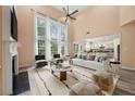Bright living room with soaring ceilings, fireplace, and open layout to kitchen at 5156 Amberden Hall Dr, Suwanee, GA 30024