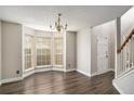 Bright living room featuring hardwood floors, a bay window, and modern lighting at 6092 Giles Ct, Lithonia, GA 30058
