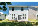 Back of a two-story home with vinyl siding and a small patio overlooking a nice lawn at 7268 Loblolly Ln, Morrow, GA 30260