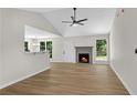 Bright open-plan living room showcasing hardwood floors, a cozy fireplace, and a vaulted ceiling at 8592 Hidden Creek Cir, Snellville, GA 30039