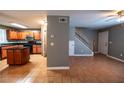 Open-concept kitchen featuring wood cabinets and staircase to second floor at 122 Summer Pl, Norcross, GA 30071