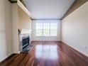 Spacious living room features a fireplace, hardwood floors, and a large window with natural light at 200 Renaissance Ne Pkwy # 310, Atlanta, GA 30308