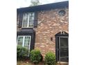 Charming brick townhome exterior featuring detailed architectural accents and lush, manicured landscaping at 658 Garden Walk Dr, Stone Mountain, GA 30083