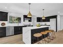 Modern kitchen featuring black cabinets, stainless appliances, marble island, and pendant lighting at 696 Kenilworth Cir, Stone Mountain, GA 30083