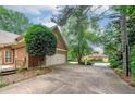 Long driveway leading to a two-car garage surrounded by mature trees and lush landscaping at 170 Glen Eagle Way, Mcdonough, GA 30253