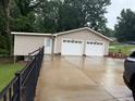 Exterior view of a two-car garage with adjacent storage area and a paved driveway at 3964 Hamilton Mill Rd, Buford, GA 30114