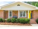 Close up of the brick home's front door and porch with decorative plants at 8070 Johnson Rd, Palmetto, GA 30268