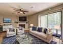 Nicely staged living room with fireplace, hardwood floors, ceiling fan, and sliding doors to outdoor deck at 129 Lester Nw Rd, Lawrenceville, GA 30044