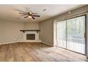 Bright living room with hardwood floors, fireplace, ceiling fan, and sliding doors to outdoor deck at 129 Lester Nw Rd, Lawrenceville, GA 30044