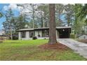 Charming single-story home featuring a covered carport and freshly landscaped yard with mature trees at 3351 Landrum Se Dr, Smyrna, GA 30082