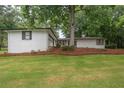 A large yard features well-maintained lawn and perimeter landscaping with mature trees at 7505 Rico Rd, Chattahoochee Hills, GA 30268