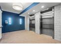Modern building elevators with stainless steel doors and tiled walls, with blue accent wall at 1100 Howell Mill Nw Rd # 212, Atlanta, GA 30318