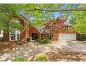 Charming brick home with a circular driveway and a well-manicured front lawn at 4820 Coppedge Trl, Peachtree Corners, GA 30096