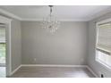 Charming dining room with elegant chandelier, neutral paint, and sunlit windows overlooking the property at 2553 Country Club Dr, Conyers, GA 30013
