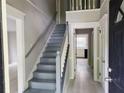 Inviting foyer with staircase, light gray walls, white trim, and durable floors lead into the home's interior at 2553 Country Club Dr, Conyers, GA 30013