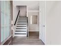 Bright entryway with a modern staircase featuring black and white accents and sleek, light-colored hardwood flooring at 2560 Clairebrooke Bnd, Atlanta, GA 30341