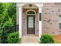 Inviting front door with arched window, flanked by white columns and lush greenery, offers a warm welcome at 2560 Clairebrooke Bnd, Atlanta, GA 30341