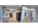 Well-lit kitchen with stainless steel appliances and white cabinets with an open view to the foyer at 1230 Chris Lake Dr, Lawrenceville, GA 30046