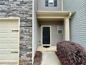 Close up of gray home featuring a black front door and garage door, with stone accents at 664 Oakside Pl, Acworth, GA 30102