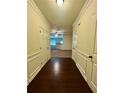 Hallway with wood floors and paneled walls leading to a carpeted living space at 664 Oakside Pl, Acworth, GA 30102