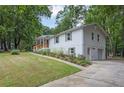 Stylish white home with an attached garage, driveway, and lush green lawn at 5666 Fawn Dr, Powder Springs, GA 30127