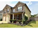 Attractive two-story home with manicured landscaping, a covered porch, and a two-car garage at 558 Hideaway Dr, Jonesboro, GA 30238