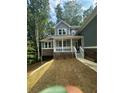 Inviting two-story home with a covered front porch, stone accents, and a freshly landscaped yard at 1119 Plantation Se Dr, Conyers, GA 30094