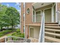 Exterior apartment detail showing brick facade with stairway access to upper units and lush greenery surrounding the building at 245 Amal Sw Dr # 2018, Atlanta, GA 30315