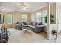 Cozy living room featuring a comfortable gray sectional sofa, plush carpeting, and ample natural light from large windows at 245 Amal Sw Dr # 2018, Atlanta, GA 30315