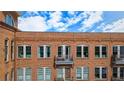 Close-up of the brick building facade and a balcony accessible by a glass door at 360 Chambers St # 405, Woodstock, GA 30188