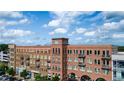 Multi-story building with brick and tan facades featuring private balconies on a partly cloudy day at 360 Chambers St # 405, Woodstock, GA 30188