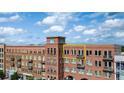 A multi-story building featuring brick facade and private balconies on a sunny day at 360 Chambers St # 405, Woodstock, GA 30188