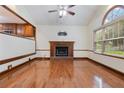Sunlit living room with hardwood flooring and a brick fireplace, adjacent to the kitchen at 48 Saddle Field Nw Cir, Cartersville, GA 30121