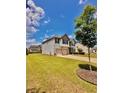 Two-story home featuring a well-manicured lawn, two-car garage and a driveway at 520 Harmony Way, Locust Grove, GA 30248