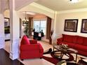 Inviting living room with red sofas, decorative columns, and bright natural light at 520 Harmony Way, Locust Grove, GA 30248