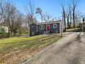 Home exterior with a gray facade, a red door, a well-maintained lawn, and a long driveway at 1406 Kennesaw Nw Dr, Atlanta, GA 30318