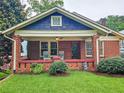 Charming brick home with a cozy front porch featuring rocking chairs and lush green landscaping at 147 Olympic Pl, Decatur, GA 30030
